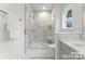 Bright bathroom featuring a glass enclosed shower with marble walls, seat, window, and marble floors at 3627 Rogers St, Charlotte, NC 28208