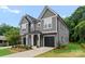 Modern gray duplex with a black roof, manicured lawn, and individual driveways leading to attached garages at 3627 Rogers St, Charlotte, NC 28208