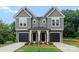 Charming gray duplex featuring well-maintained landscaping, black garage doors, and covered entrances at 3627 Rogers St, Charlotte, NC 28208