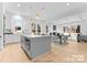 Gourmet kitchen with a large island, stainless steel appliances, hardwood floors, and modern lighting at 3627 Rogers St, Charlotte, NC 28208