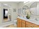 Well-lit bathroom with a double vanity, round mirrors, and decorative flower arrangement at 3757 Fieldhaven Ct, Maiden, NC 28650
