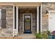 Inviting covered front porch with stone accents, columns and a decorative wreath on the front door at 393 Brannon Meadows Dr, York, SC 29745