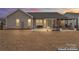 Large backyard with a patio, furniture, lighting, and a virtually enhanced sky at 4000 Spring Cove Way, Belmont, NC 28012