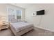 Cozy bedroom with neutral tones, a large window, and a mounted television at 4000 Spring Cove Way, Belmont, NC 28012