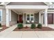 Inviting front porch featuring white columns, a red front door, and meticulously maintained landscaping at 4000 Spring Cove Way, Belmont, NC 28012