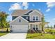 Charming two-story home with gray and blue siding, a two-car garage, and a well-maintained front yard at 4004 Caymen Bay Ct, Tega Cay, SC 29708