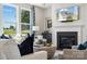 Cozy living room with a fireplace, hardwood floors, large windows, and elegant decor at 4004 Caymen Bay Ct, Tega Cay, SC 29708