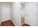 Bright hallway with hardwood floors, white doors, and a view into a carpeted room, creating a seamless transition at 5216 Crystal Lakes Dr, Rock Hill, SC 29732