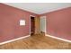 A bright bedroom with hardwood floors, an open closet, and views to another room at 906 Forest Dr, Lancaster, SC 29720