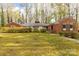 Charming single-story brick home featuring lush landscaping and a well-manicured lawn in a quiet neighborhood at 906 Forest Dr, Lancaster, SC 29720