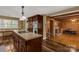 Open-concept kitchen view leading into a cozy living room with wood fireplace and exposed beam ceiling at 906 Forest Dr, Lancaster, SC 29720