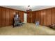 A living room with wood paneling, carpet, and a view to another room through a doorway at 906 Forest Dr, Lancaster, SC 29720