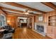 Living room with stone fireplace, wood paneled walls and hardwood floors at 906 Forest Dr, Lancaster, SC 29720