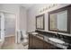 Double sink bathroom vanity featuring dark wood cabinets, granite counters, and framed mirrors at 151 Kallie Loop, Mooresville, NC 28117