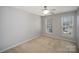 This gray bedroom has neutral carpet, two windows, and a ceiling fan at 151 Kallie Loop, Mooresville, NC 28117