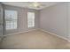 This is a gray bedroom with neutral carpet, two windows, and a ceiling fan at 151 Kallie Loop, Mooresville, NC 28117
