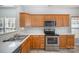 Kitchen features stainless steel appliances, white subway tile backsplash, light countertops, and natural wood cabinets at 151 Kallie Loop, Mooresville, NC 28117