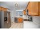 Stainless steel appliances, light countertops, and wood cabinets in this transitional kitchen at 151 Kallie Loop, Mooresville, NC 28117