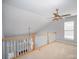 Upstairs loft area with neutral carpet, ceiling fan and decorative railing at 151 Kallie Loop, Mooresville, NC 28117