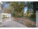 View of the home's tile patio with lush landscaping and wooded backyard at 151 Kallie Loop, Mooresville, NC 28117