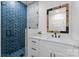 Modern bathroom with blue-tiled shower, white vanity, and stylish framed mirror, offering a serene spa-like feel at 1575 Shinnville Rd, Cleveland, NC 27013