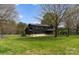 Acreage with a black modern home featuring a stone base and an outdoor patio at 1575 Shinnville Rd, Cleveland, NC 27013