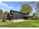 Exterior view of black modern home featuring a stone base and an outdoor patio at 1575 Shinnville Rd, Cleveland, NC 27013