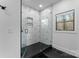 Modern glass shower with black hardware and unique geometric tiling, and a large window at 1575 Shinnville Rd, Cleveland, NC 27013