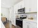 Modern kitchen features stainless steel appliances and white cabinetry with stylish backsplash at 1720 Coral Bark Ln # Kh15, Charlotte, NC 28216