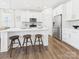 Bright kitchen boasts a large island with seating, stainless steel fridge, and modern finishes at 1720 Coral Bark Ln # Kh15, Charlotte, NC 28216