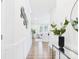 Bright hallway leading to a modern living room with hardwood floors and white furniture at 1720 Coral Bark Ln # Kh15, Charlotte, NC 28216