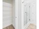 A bright bathroom featuring a glass enclosed shower and shelving unit, offering a pristine and efficient space at 2009 White Cypress Ct # Kh13, Charlotte, NC 28216