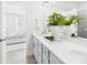 A spacious bathroom boasting dual sinks, quartz countertops, modern lighting, and views into a calming bedroom at 2009 White Cypress Ct # Kh13, Charlotte, NC 28216