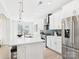 Modern kitchen with stainless steel appliances, a large island, and sleek white cabinetry at 2009 White Cypress Ct # Kh13, Charlotte, NC 28216