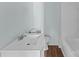 Bathroom featuring a white vanity with sink and toilet, and wood flooring at 208 W Lafayette St, Salisbury, NC 28144