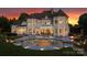 Luxury home showcasing a stunning pool with water feature, patio, and manicured lawn at 2477 Peninsula Shores Ct, Denver, NC 28037