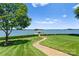 Lush backyard featuring a manicured lawn, a charming pathway to the lake, and a private dock at 2477 Peninsula Shores Ct, Denver, NC 28037