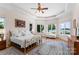 Bright bedroom featuring hardwood floors, a gold metal bed frame, and beautiful lake views at 2477 Peninsula Shores Ct, Denver, NC 28037