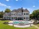 Grand exterior of the lakefront home, featuring a backyard pool, patio, and manicured lawn at 2477 Peninsula Shores Ct, Denver, NC 28037