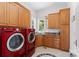 Bright laundry room with stainless steel washer and dryer, wood cabinets, and a utility sink at 2477 Peninsula Shores Ct, Denver, NC 28037