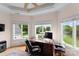 Bright office space with a large wooden desk, natural light, and views of the well-manicured front yard at 2477 Peninsula Shores Ct, Denver, NC 28037