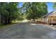 Long driveway leading to home with side yard, brick flowerbeds, and mature trees at 28419 Nc Hwy 73 Hwy, Albemarle, NC 28001