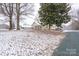 Quaint single-story home nestled among mature trees, with snow adding a touch of winter charm to the landscape at 28419 Nc Hwy 73 Hwy, Albemarle, NC 28001