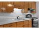Up-close kitchen featuring wood cabinets, a stainless steel sink, and white subway tile at 28419 Nc Hwy 73 Hwy, Albemarle, NC 28001