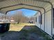 Rear view of the home with a covered carport and large backyard with ample space at 3481 Roberta Rd, Concord, NC 28027