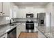 A close-up view of a kitchen, showcasing granite countertops, stainless steel appliances, and white cabinets at 3527 Clover Valley Dr, Gastonia, NC 28052