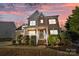 Inviting two-story home with a brick facade, covered porch, and landscaped front yard bathed in twilight hues at 437 Buttermere Rd # 31, Fort Mill, SC 29715
