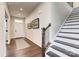 Inviting foyer with hardwood floors, a staircase, and tastefully framed artwork, creating a warm and welcoming entrance at 496 Kenyon Dr, Denver, NC 28037