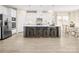 Spacious kitchen with stainless steel appliances, a gray island with stool seating, and light wood flooring at 497 Kenyon Dr, Denver, NC 28037
