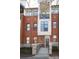 Modern townhome with a brick facade, balcony, and a welcoming front entrance with landscaped yard at 530 N Mcdowell St, Charlotte, NC 28204